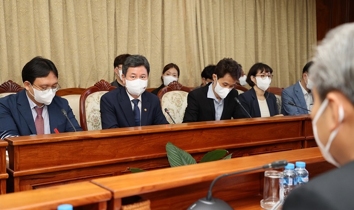 마스크를 쓴 사람들이 테이블에 앉아 있는 모습 마스크를 쓴 사람들이 테이블에 앉아 있는 모습